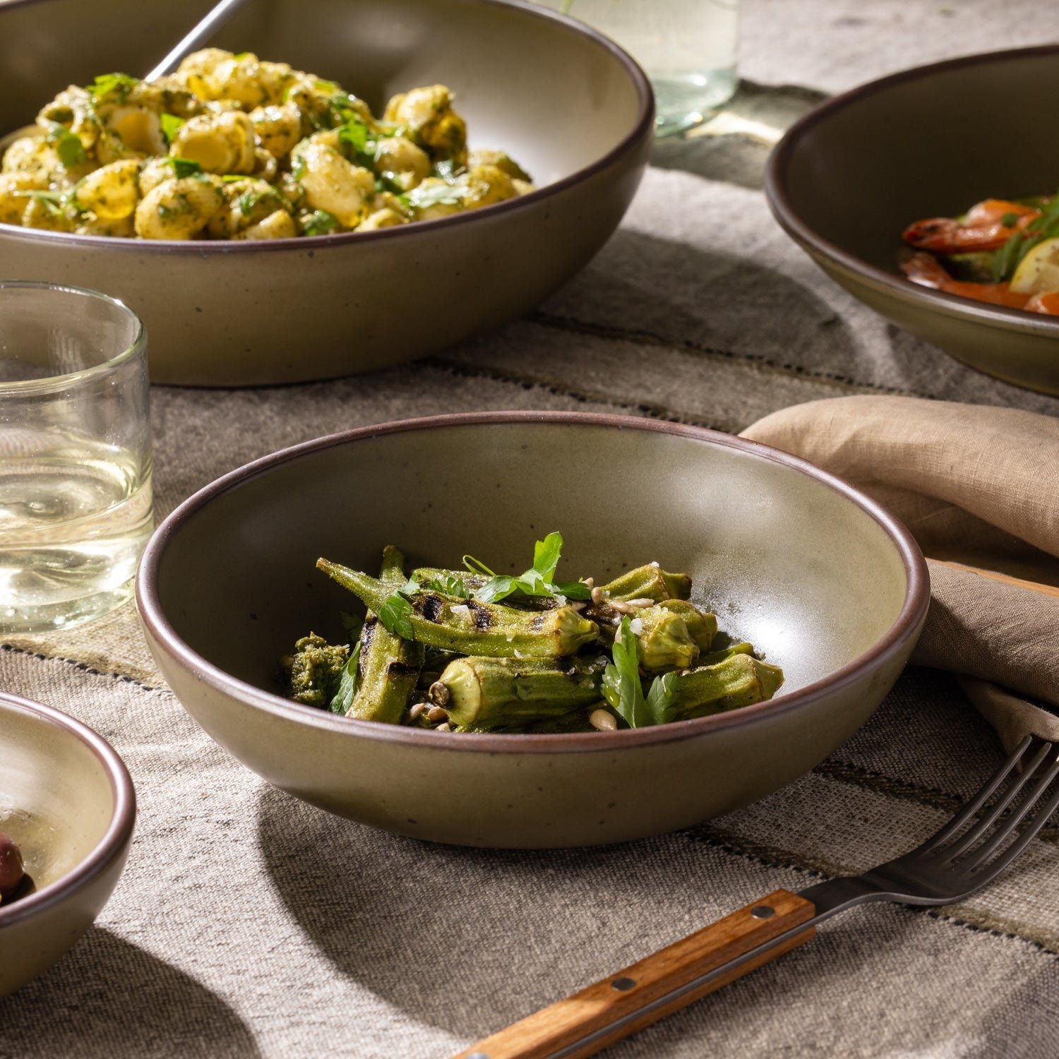 Lunessia daily bowl in Pine Green, shown with vegetables in a table setting