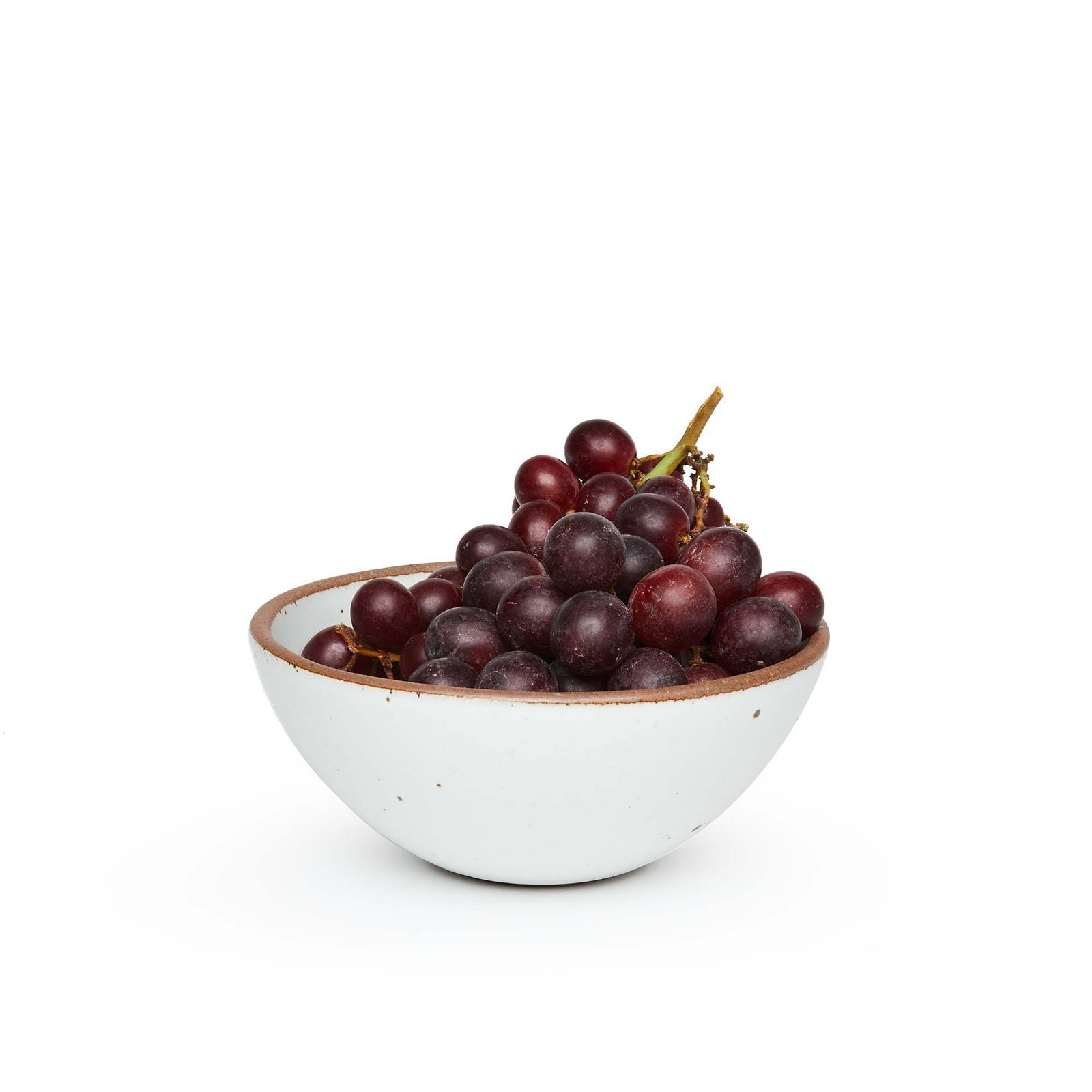 Lunessia soup bowl in Cloud White, shown with grapes