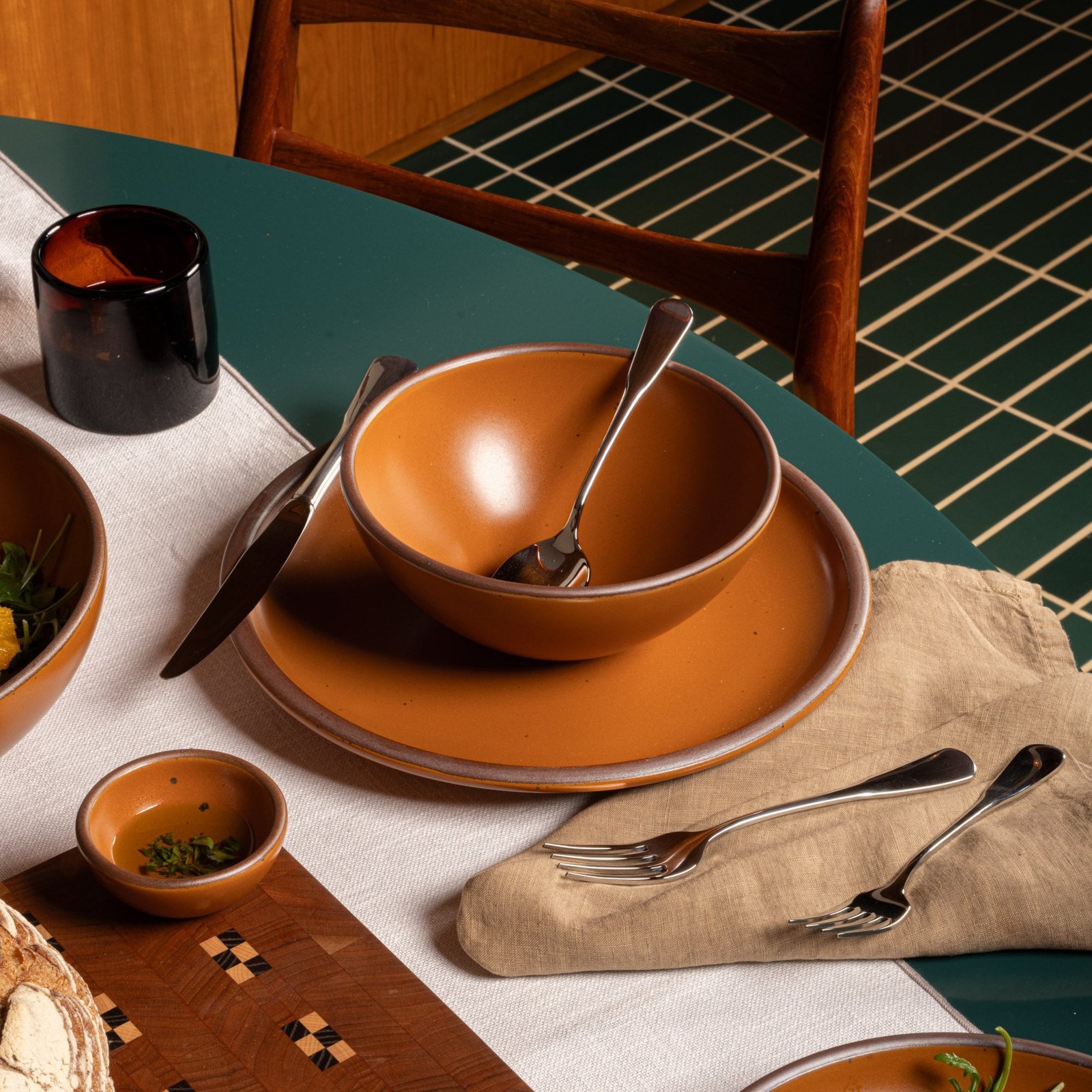 Lunessia soup bowl in Ember, in a table setting with other dinnerware